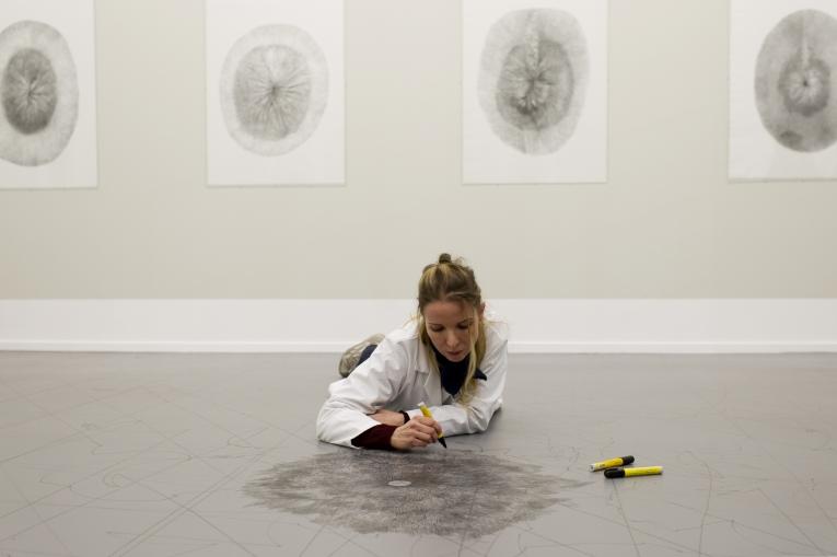 Artist lying on floor drawing