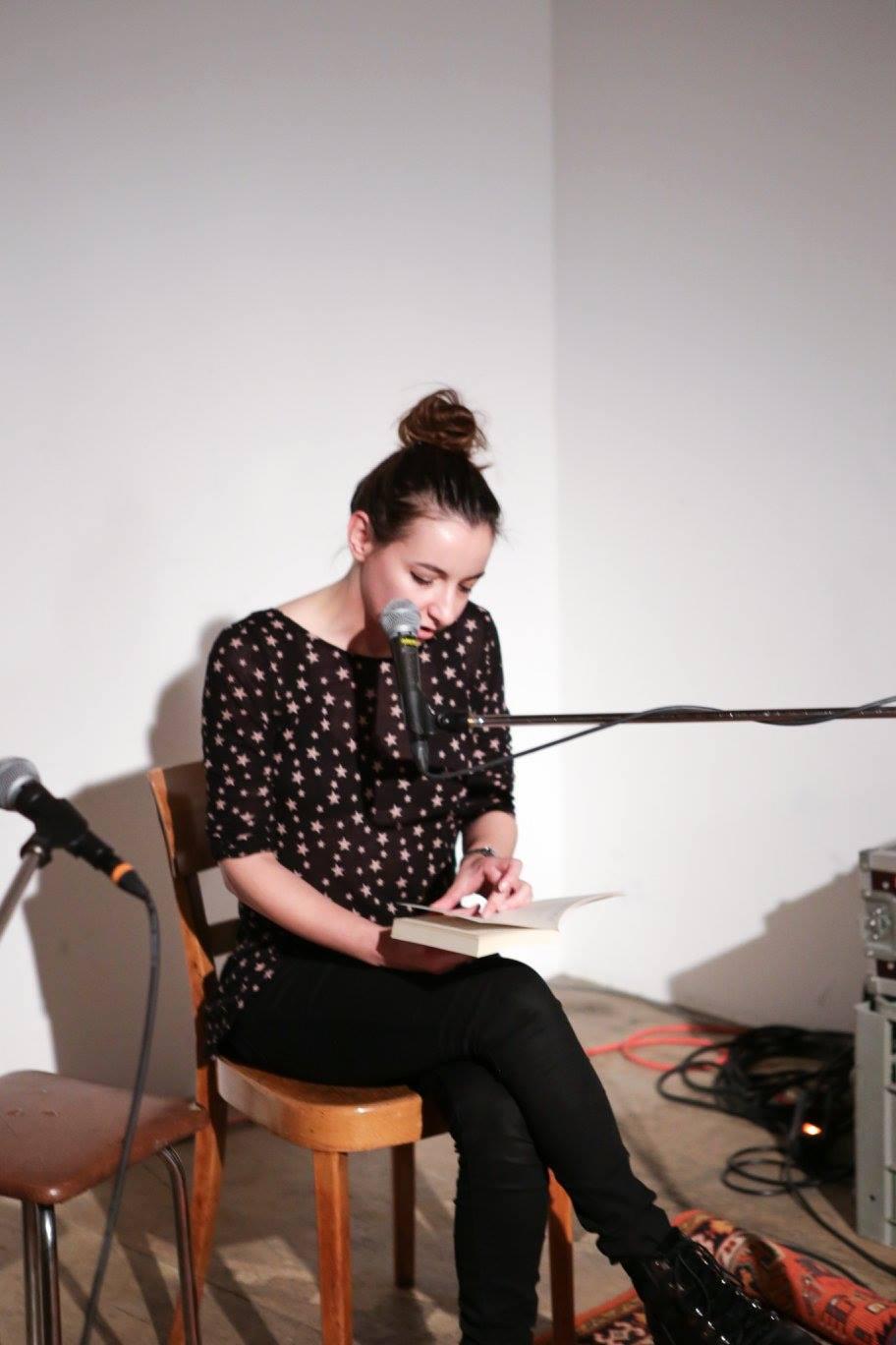 Girl in front of a microphone, reading a text