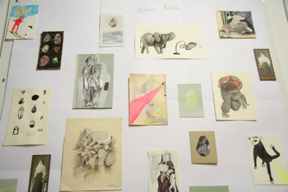 A wall with drawings and paintings